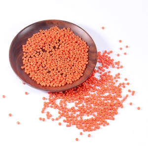 Orange 2.5-4mm glass seed beads for DIY jewelry making in a wooden bowl on white background