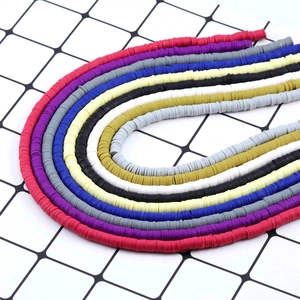 Nahaufnahme bunter 6mm Heishi-Polymer-Tonscheiben in U-förmigen Strängen für DIY-Schmuck