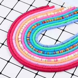 Makroaufnahme bunter Heishi-Perlen aus Fimo für DIY-Schmuck, in U-förmigen Reihen angeordnet