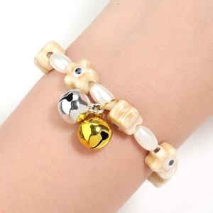 Star ceramic beads and pearl bracelet with colorful metal bells worn on wrist