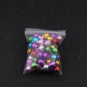 Colorful festive metal bells in a clear storage bag for DIY crafts and holiday decor