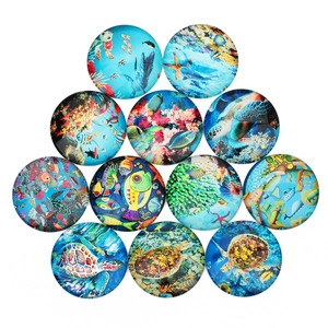 Detailed macro view of 12 circular glass cabochons with colorful sea turtle and fish patterns
