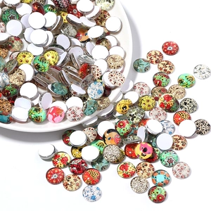 Detailed view of assorted round glass cabochons with mandala and floral tree patterns