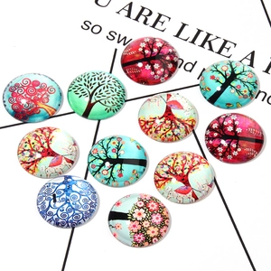 Macro detail of 11 glass cabochons with colorful tree of life and ethnic elephant patterns
