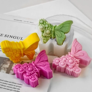 Detail of butterfly silicone mold with floral wings and colorful plaster casting results