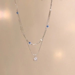 Detailed macro view of double-layered necklace with sparkling zircon star pendant