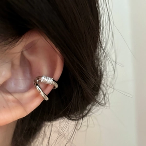 Detailed macro view of a silver double-layer ear cuff featuring pavé set zircons.