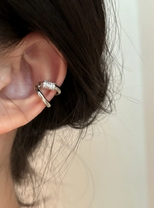 Close-up of double-layer silver ear cuff with sparkling zircons shown on a person's ear