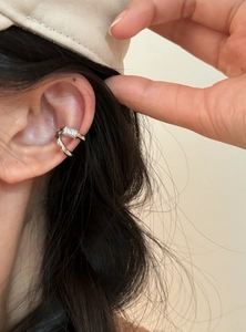 Κοντινό πλάνο ενός κομψού ασημένιου ear cuff διπλής στρώσης με ζιργκόν σε μοντέλο.