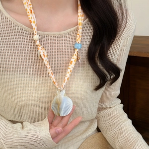 Summer beach resort style printed fabric necklace with a natural seashell pendant.