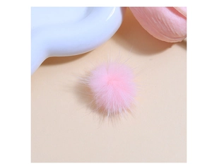 Close-up of a fluffy pink faux fur pompom for DIY handmade craft and fashion accessories