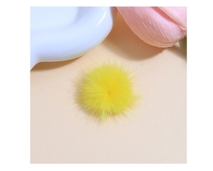 Macro shot of fluffy bright yellow faux fur pom-pom for DIY crafts and accessories