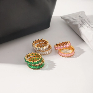 Detailed view of stacked zircon rings set in green, white and pink sparkling crystals