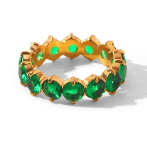 Macro view of gold-plated eternity ring with circular green gemstones in claw setting