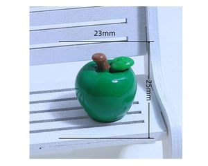Detail of a 25mm miniature green resin apple figurine on a tiny white wooden bench