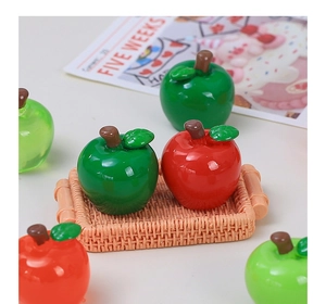 Detailed macro view of glossy resin red and green 3D apple charms in a mini basket