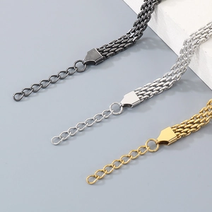 Nahaufnahme von Edelstahl-Mesh-Armbändern in Schwarz, Silber und Gold mit Verlängerungskette.