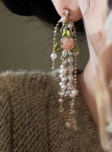 Detailed close-up of long French retro rose and pearl tassel earrings on a model's ear.