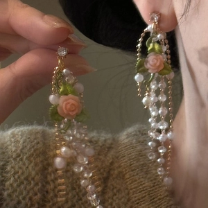 Exquisite detail of French vintage rose and pearl tassel earrings on an Asian model