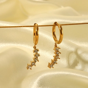Detailed view of gold stainless steel hoop earrings with curved clear stone dangles.