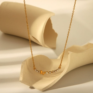 Detailed view of gold stainless steel necklace with butterfly and crystal bar pendant