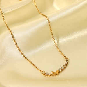 Detail view of a gold stainless steel necklace featuring a crystal butterfly pendant