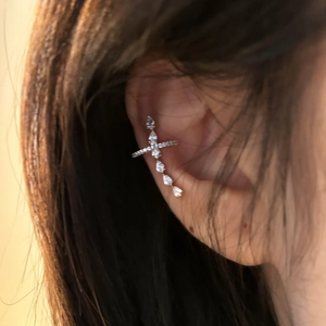 Detailaufnahme einer eleganten silbernen Kreuz-Ohrmanschette mit funkelnden Zirkonia-Steinen