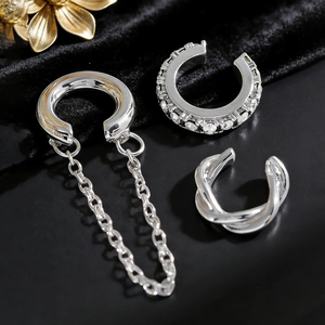 Nahaufnahme eines 3-teiligen silbernen Ear Cuff Sets mit Kettchen und Kristallbesatz