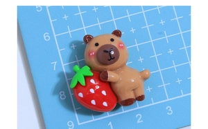 Macro view of a resin brown bear with a strawberry for DIY cream glue accessories