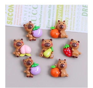 Flat lay of colorful resin bear charms holding assorted fruits for DIY jewelry making
