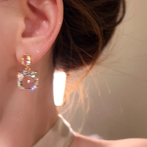 Eleganti orecchini pendenti in zirconia cubica placcati oro 18 carati su modella