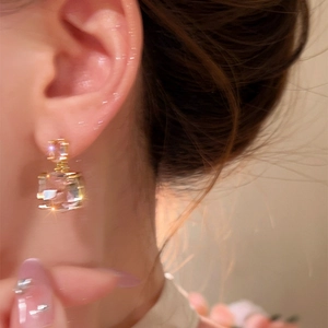 Eleganti orecchini pendenti con zirconi quadrati placcati in oro 18 carati su una modella
