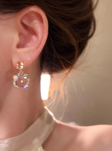 Elegante vista macro di orecchini a pendente in argento placcato oro 18k con zirconi all'orecchio