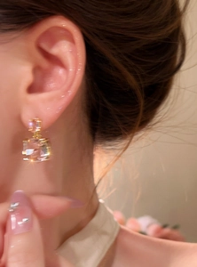 Dettaglio di orecchini a lobo in zircone rosa quadrato placcati oro 18k su modella.