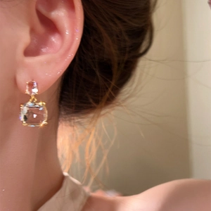 Detailed close-up showing elegant transparent square cubic zirconia earrings worn on ear