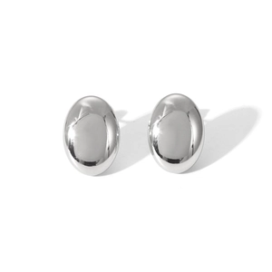 Gros plan de boucles d'oreilles clous ovales en acier inoxydable poli au fini argenté.