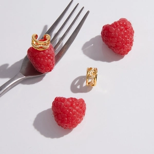 Close-up detail of gold-plated stainless steel ear cuffs with sparkling cubic zirconia.