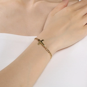 Macro view of a gold-plated stainless steel ankh cross bracelet on a woman's wrist