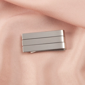 High-quality detailed macro view of the brushed finish on a silver stainless steel tie clip