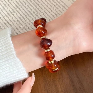 Boho-Vintage-Armband mit bernsteinfarbenen Perlen und goldenen Akzenten am Handgelenk