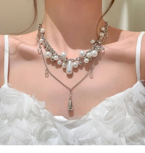 Dettaglio di un elegante collana di perle a strati francese con ciondolo in argento