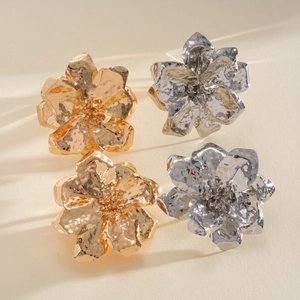 Detailed view of large wrinkled metal flower jewelry with elegant gold and silver textures