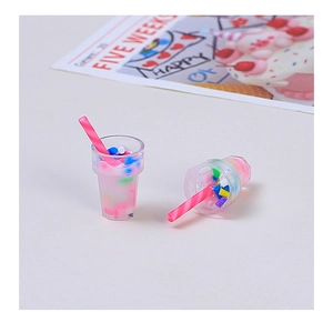 Close-up of DIY resin milk tea cup miniatures with colorful faux fruit and striped straws