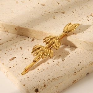 Detailed macro view of a designer gold-plated stainless steel banana-shaped hair clip