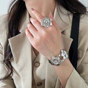 Dettaglio di un set elegante di anello e bracciale a fiore in argento con perle