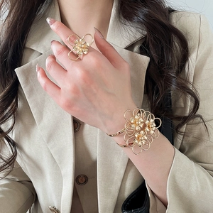 Elegante set di anello e bracciale a polsino in metallo dorato con fiori traforati