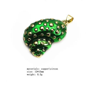 Detail view of a shell pendant featuring green enamel and zircon inlay on copper base