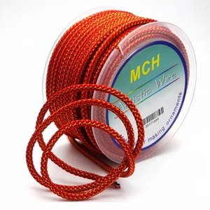 Close-up of 3.5mm red and gold dragon pattern braided cord on transparent spool