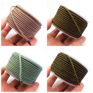 Close-up of 3.5mm metallic dragon pattern woven cords in four vibrant colors on spools