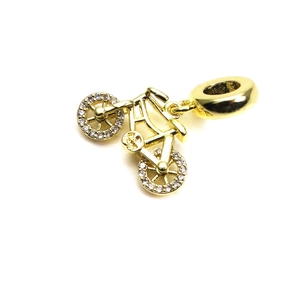 Macro shot of gold-plated bicycle charm with cubic zirconia wheel detailing and large bail